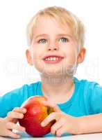 Portrait of a cute little boy with red apple