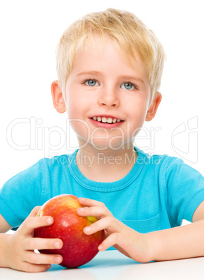 Portrait of a cute little boy with red apple