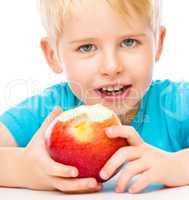 Portrait of a cute little boy with red apple