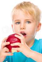 Portrait of a cute little boy with red apple