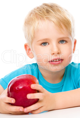 Portrait of a cute little boy with red apple