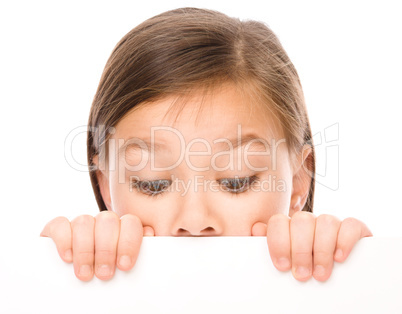 Little girl is looking from out blank board
