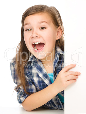 Little girl is looking from out blank board