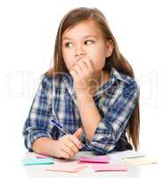 Girl is writing on color stickers using pen