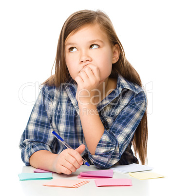 Girl is writing on color stickers using pen