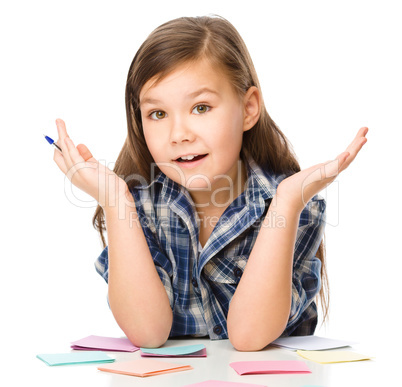 Girl is writing on color stickers using pen