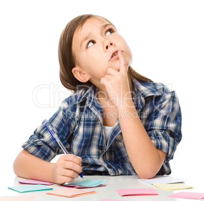 Girl is writing on color stickers using pen