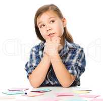 Girl is writing on color stickers using pen