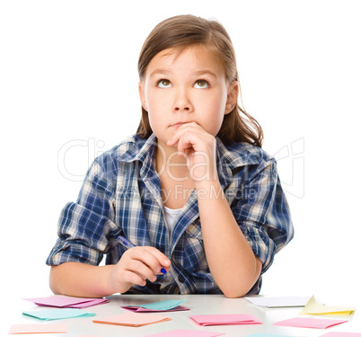 Girl is writing on color stickers using pen