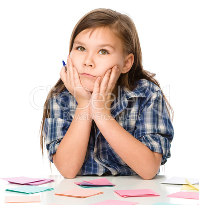 Girl is writing on color stickers using pen