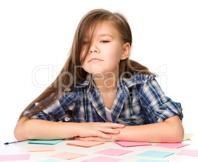 Girl is writing on color stickers