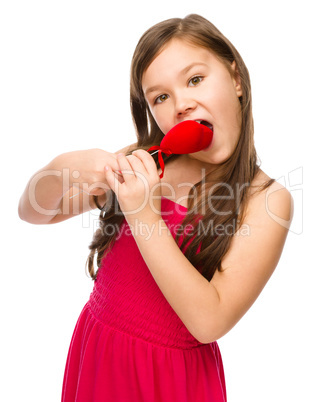 Portrait of a little girl biting red heart