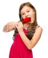 Portrait of a little girl biting red heart