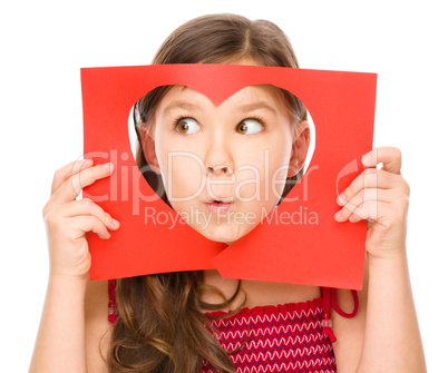 Little girl is looking through heart template