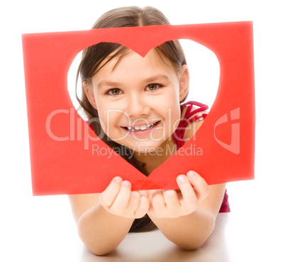 Little girl is looking through heart template