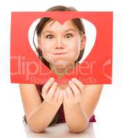 Little girl is looking through heart template