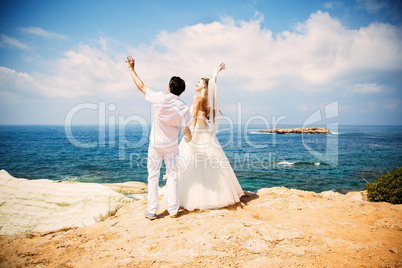Elegant bride and groom walking on the beach, wedding ceremony, Mediterranean Sea.