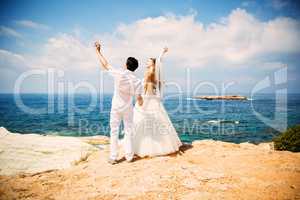 Elegant bride and groom walking on the beach, wedding ceremony, Mediterranean Sea.