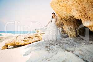 outdoor portrait of young beautiful woman bride in wedding dress on beach