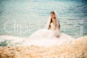 outdoor portrait of young beautiful woman bride in wedding dress on beach