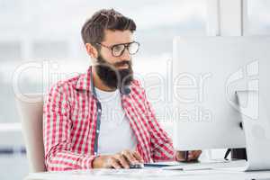 Hipster man is typing on his computer