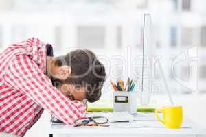 Hipster man sitting at computer desk is tired