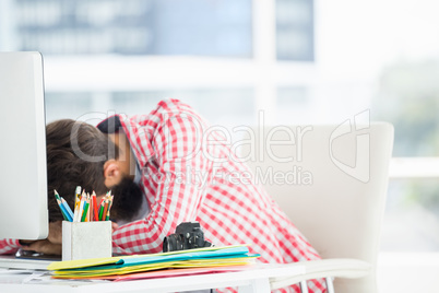 Hipster man sitting at computer desk is tired