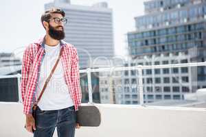 Hipster man holding his skateboard
