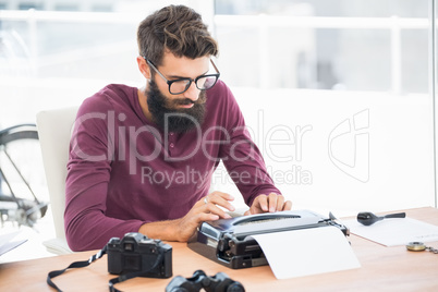 Hipster man using a typewriter