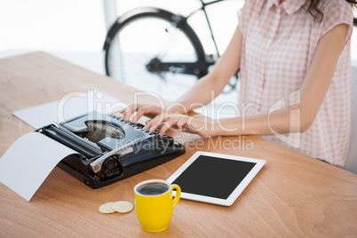 Hipster woman using a typewriter