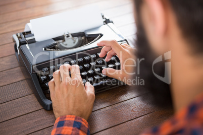 A man is typing on a type writer