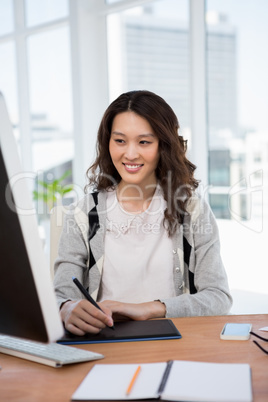 A woman is sitting at her desk