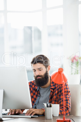 An hipster man is working on his computer