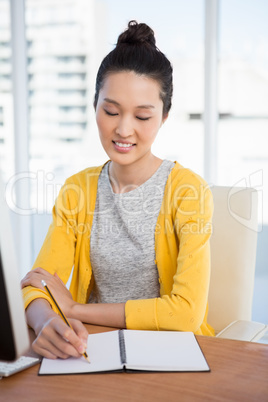 A woman is writing in a diary