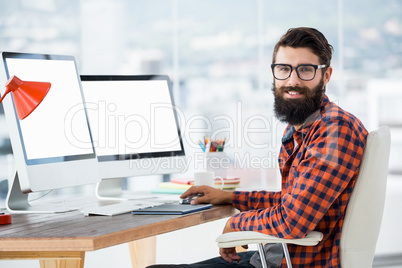 Hipster sitting in front of a computer