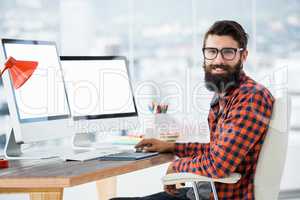 Hipster sitting in front of a computer