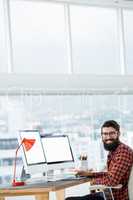 Hipster sitting in front of a computer