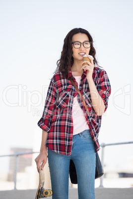 Hipster with skateboard and coffee