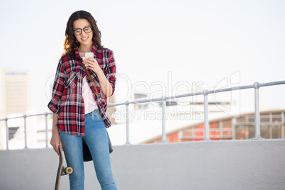 Hipster with skateboard and smartphone