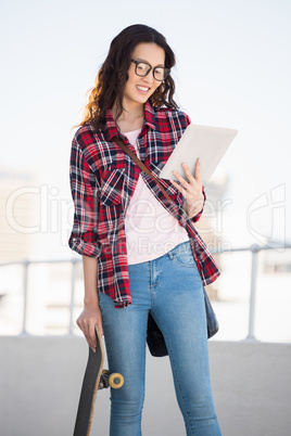 Hipster with skateboard and tablet