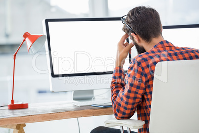 Hipster sitting in front of a computer