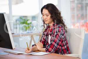 Hipster taking notes in a notebook