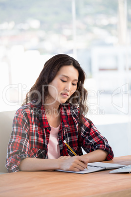 Hipster taking notes in a notebook