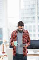 Hipster using tablet and drinking coffee