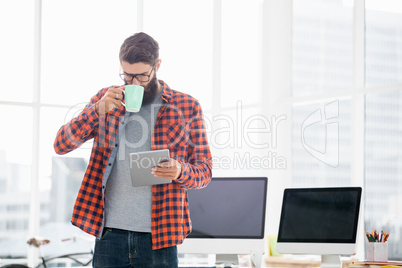 Hipster using tablet and drinking coffee