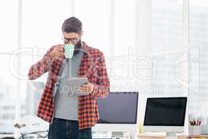 Hipster using tablet and drinking coffee