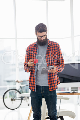 Hipster using tablet and drinking coffee