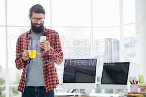 Hipster using smartphone and drinking coffee