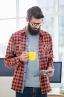 Hipster using tablet and drinking coffee