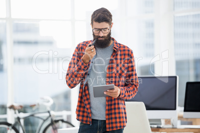 Hipster using tablet while standing